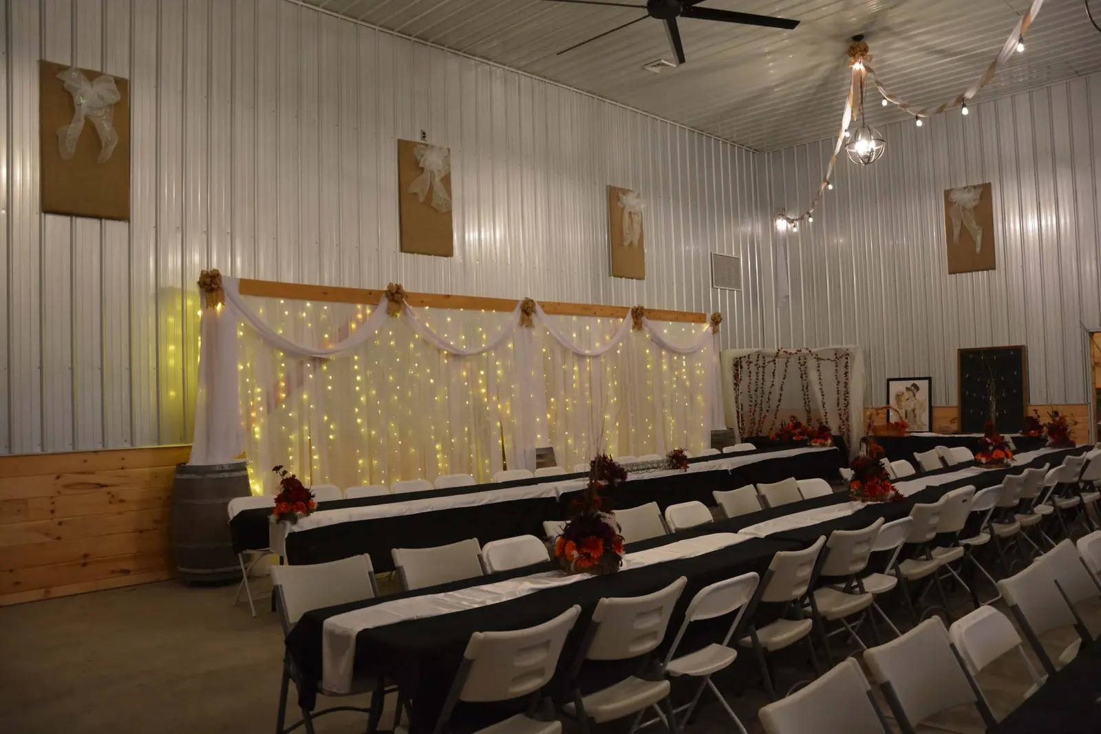 Barn reception hall set for a wedding with chandeliers and string lights